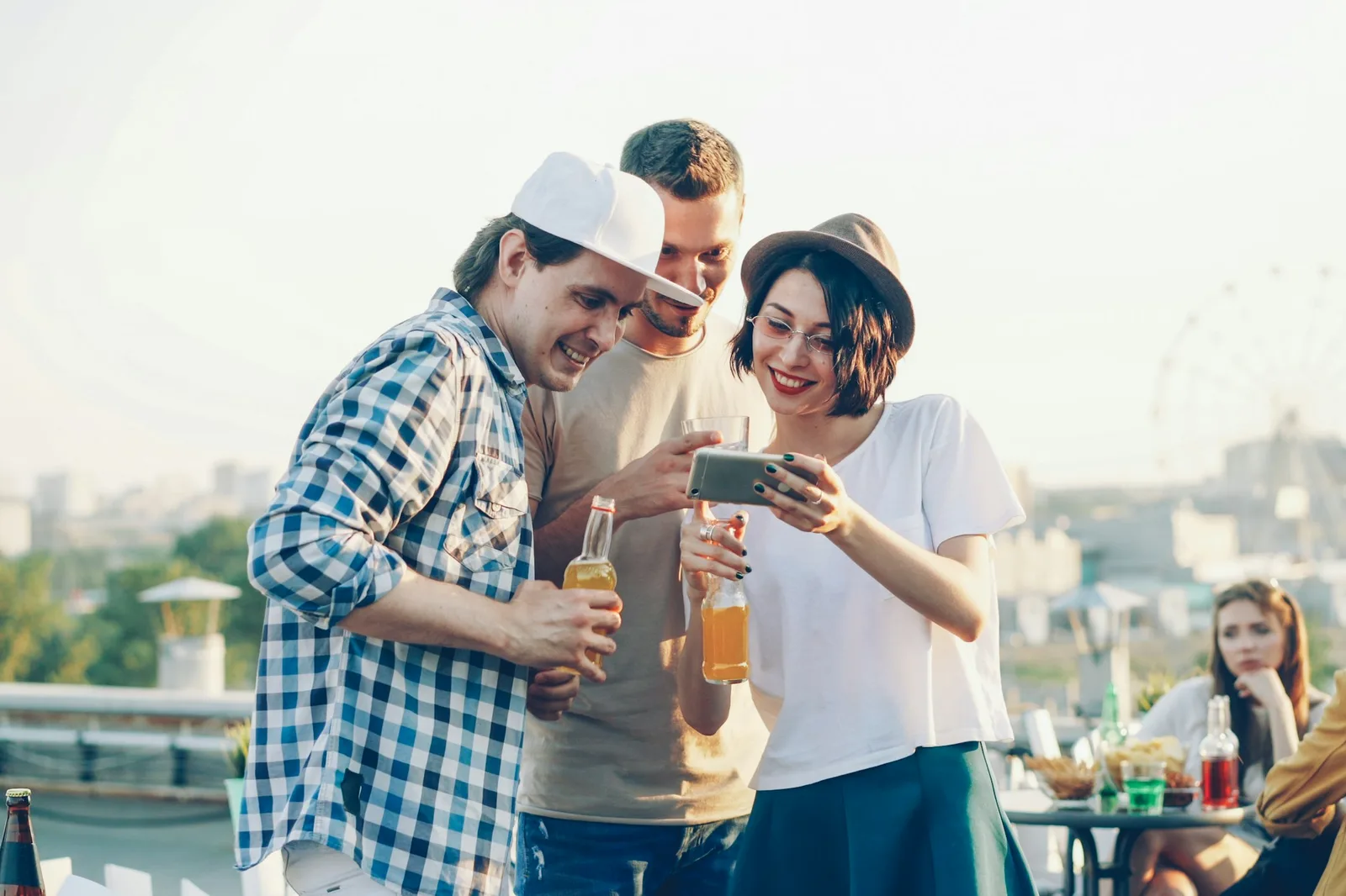 Three party guests looking through birthday photos together on one phone