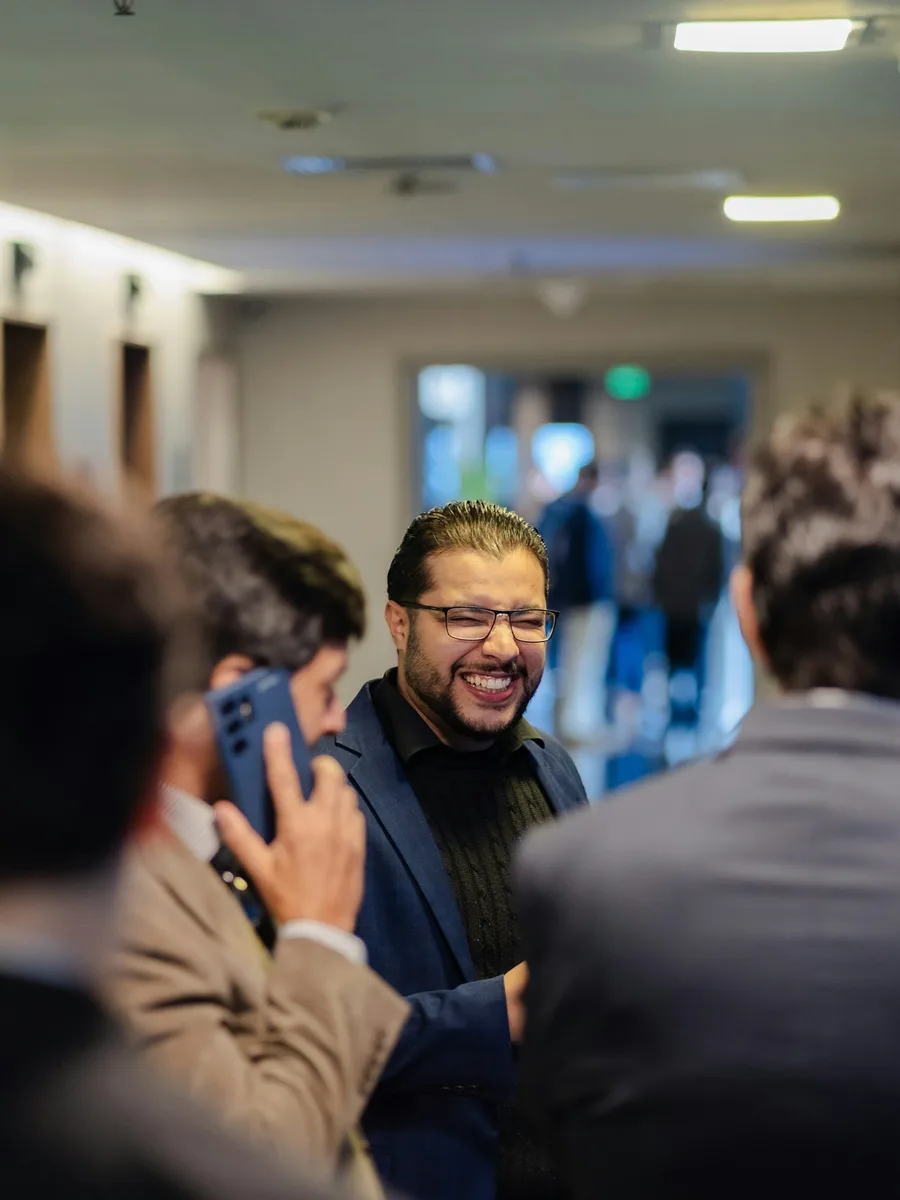Conference attendee laughing with colleagues, phone in hand